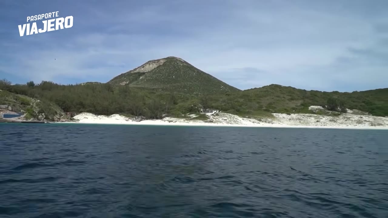 Boat approaching the protected turquoise coastline near Praia do Farol in Arraial do Cabo