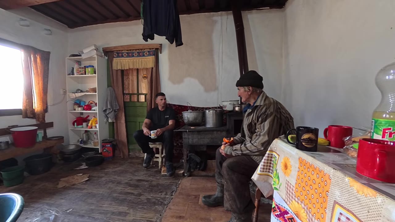 Traditional wooden buildings and green hills in rural Maramureș